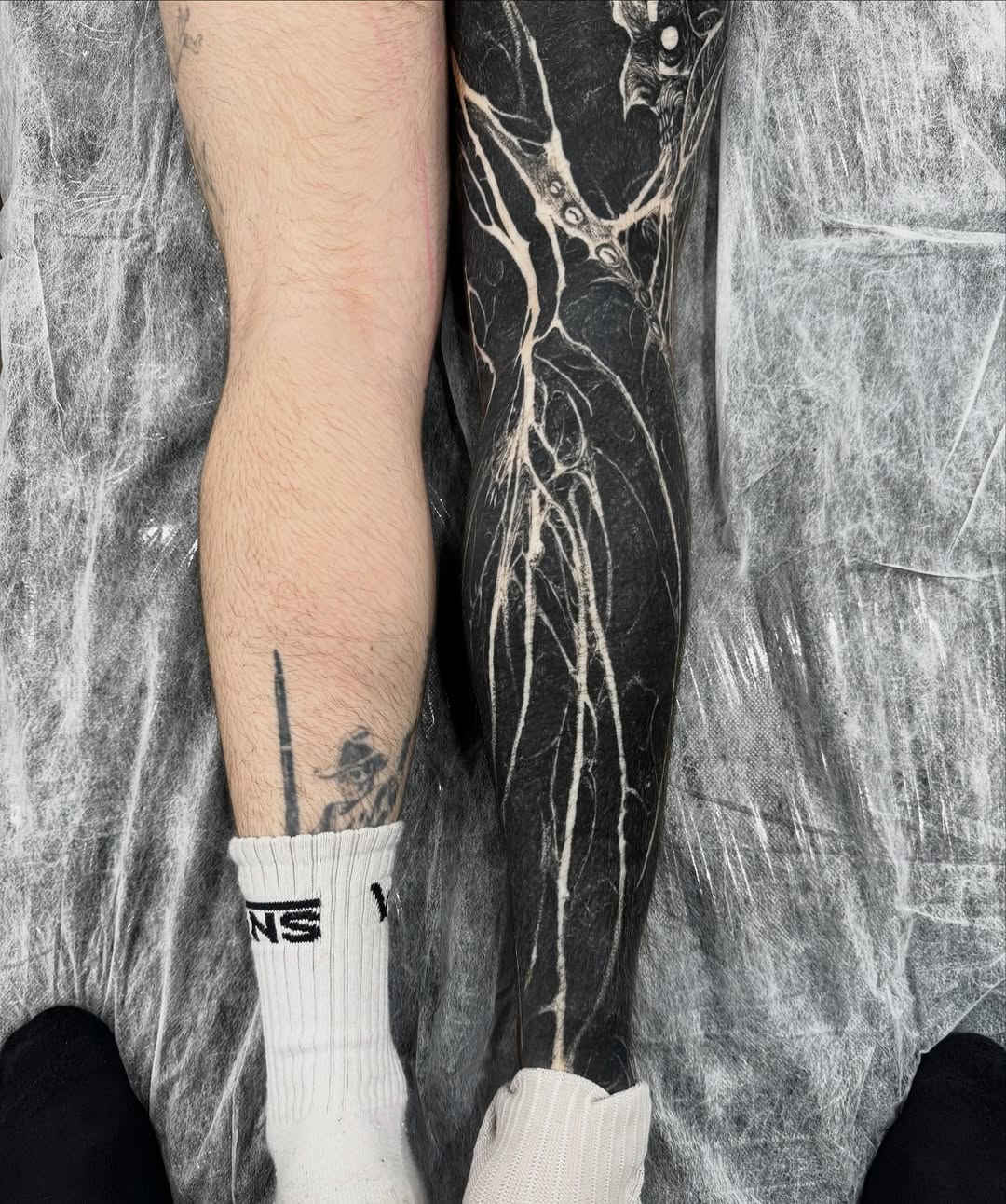 Dramatic blackwork calf sleeve with intricate white linework
