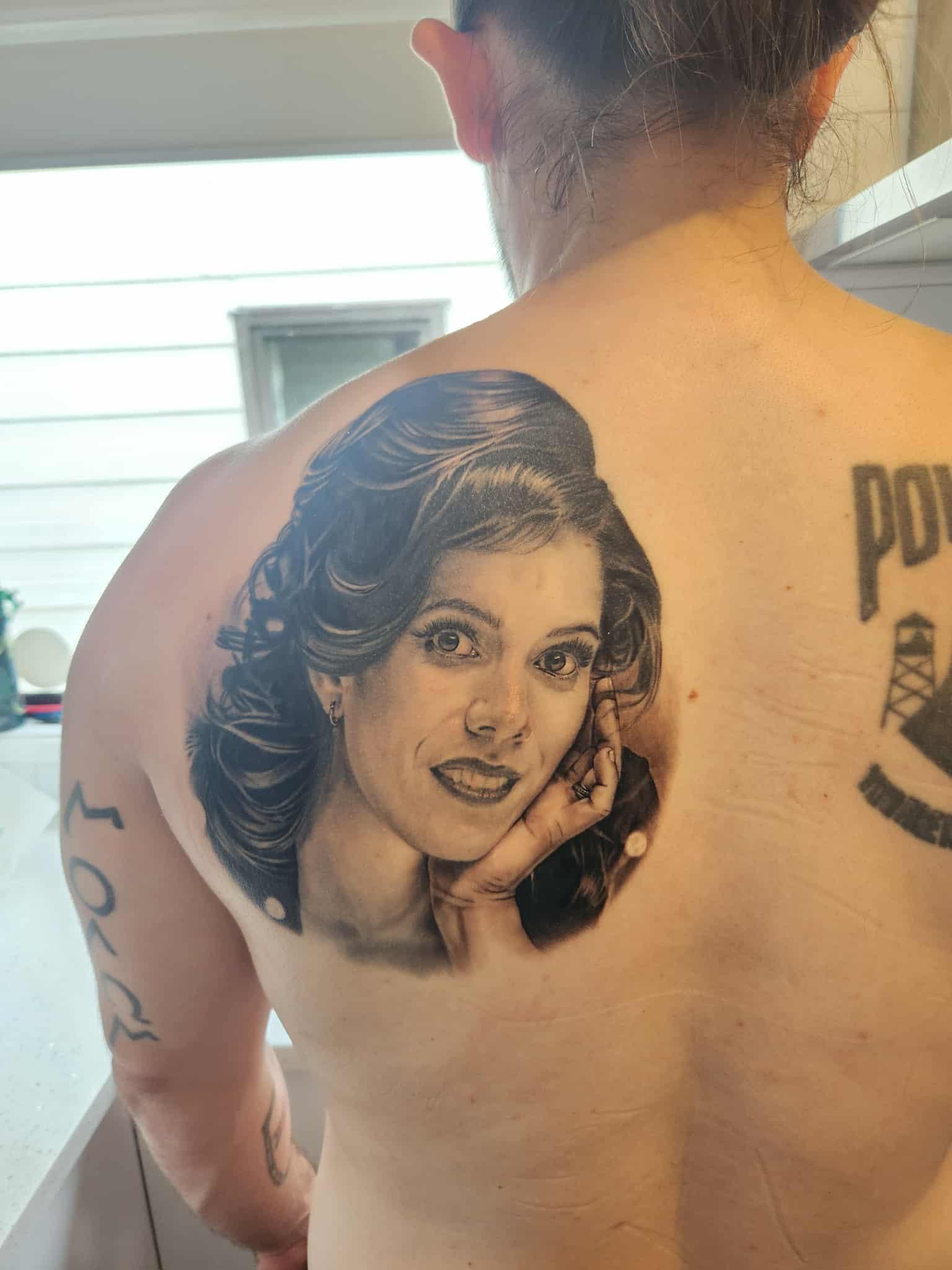 Photorealistic grayscale portrait on shoulder blade