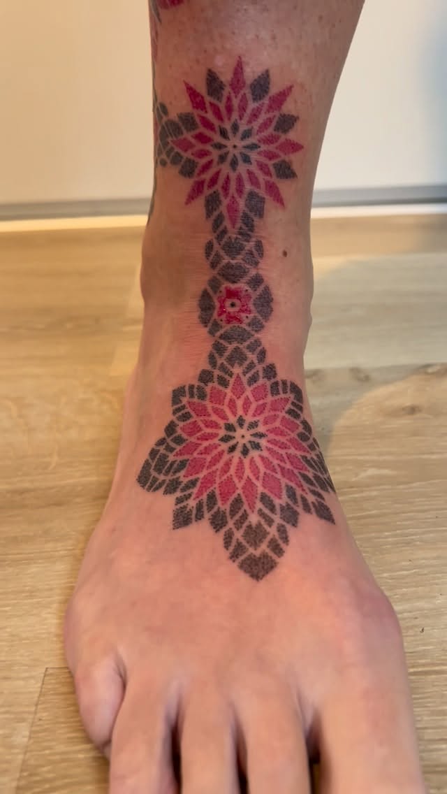 Symmetrical pink-black mandala design along ankle and foot