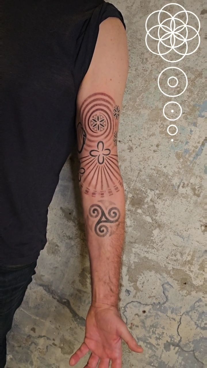 Petroglyph-inspired sunburst and spiral motifs on forearm