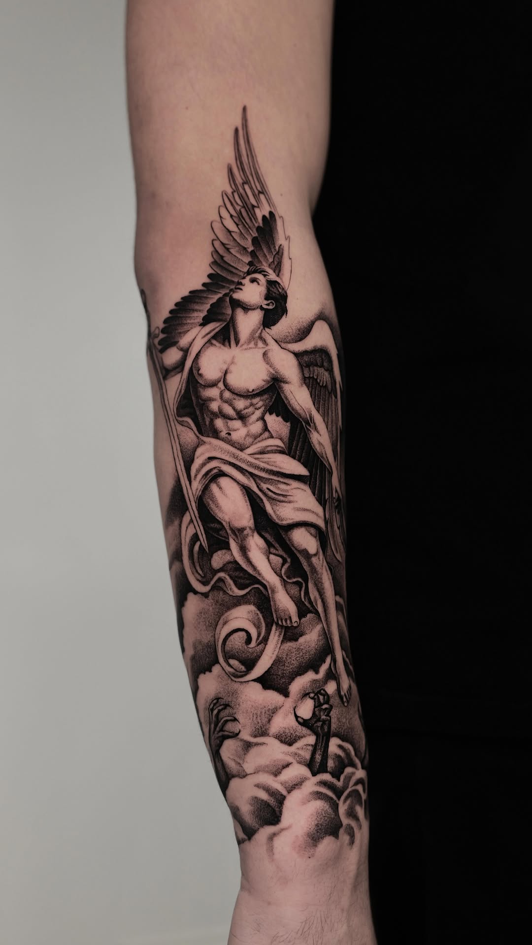 Dramatic black-and-grey angel in flight amid clouds