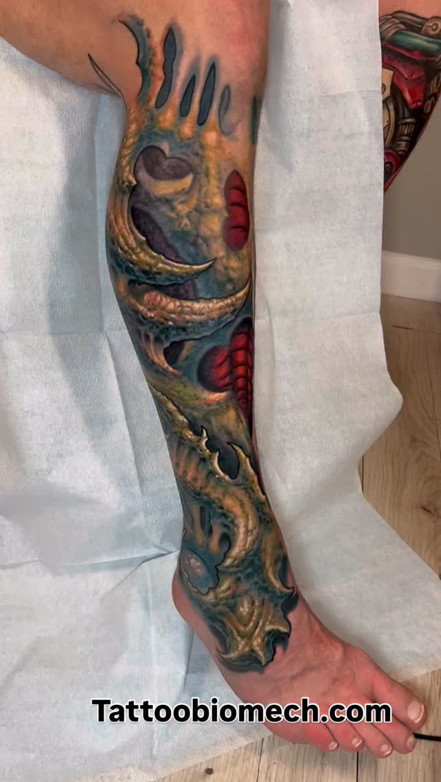 Vibrant biomechanical leg sleeve with sinewy, dragon-like forms
