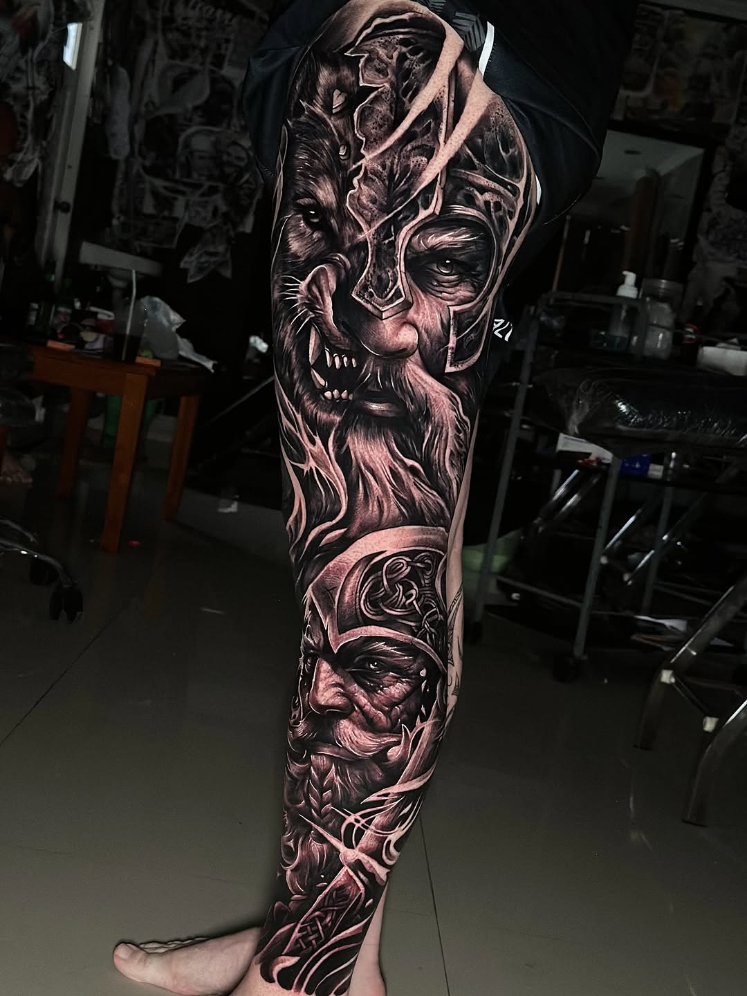 Hyper-detailed black-and-gray fantasy leg sleeve portrait.