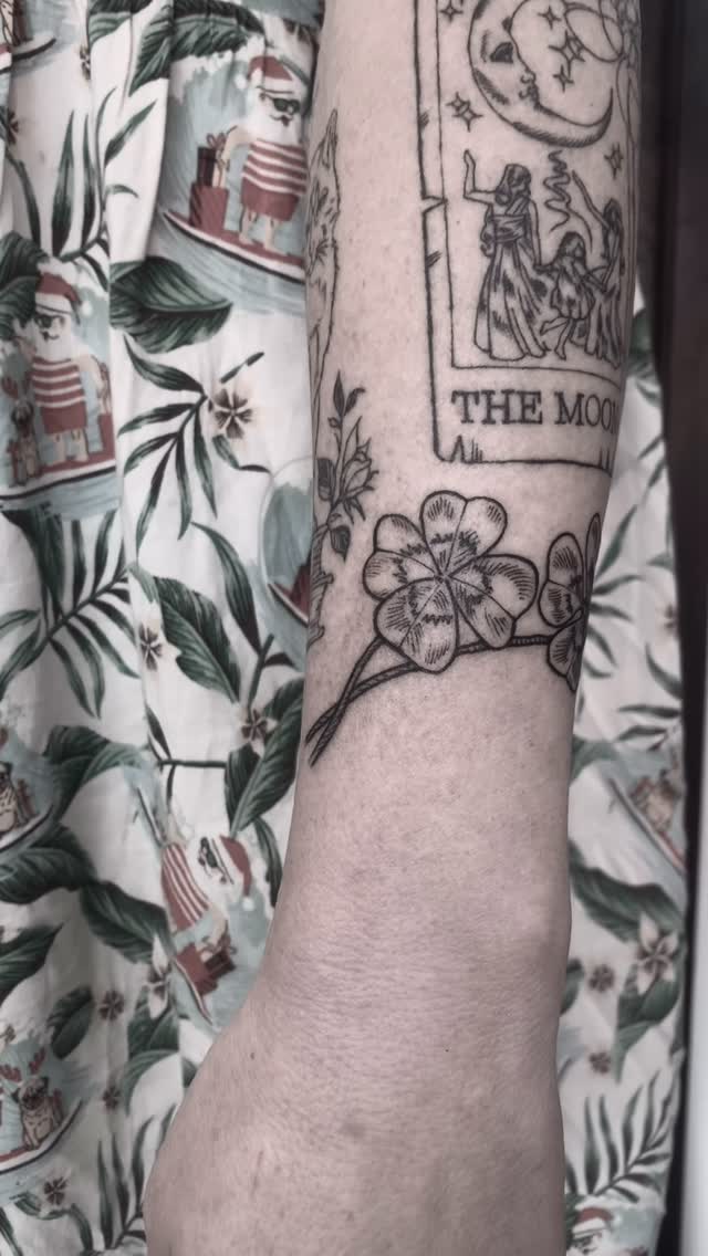 Delicate shamrock vine wraps wrist with moon frame.