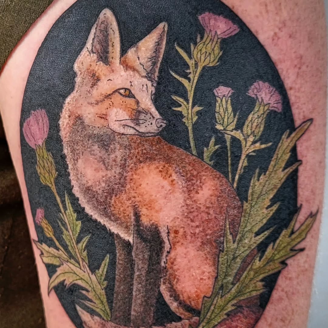 Russet fox framed in black oval, surrounded by purple thistles