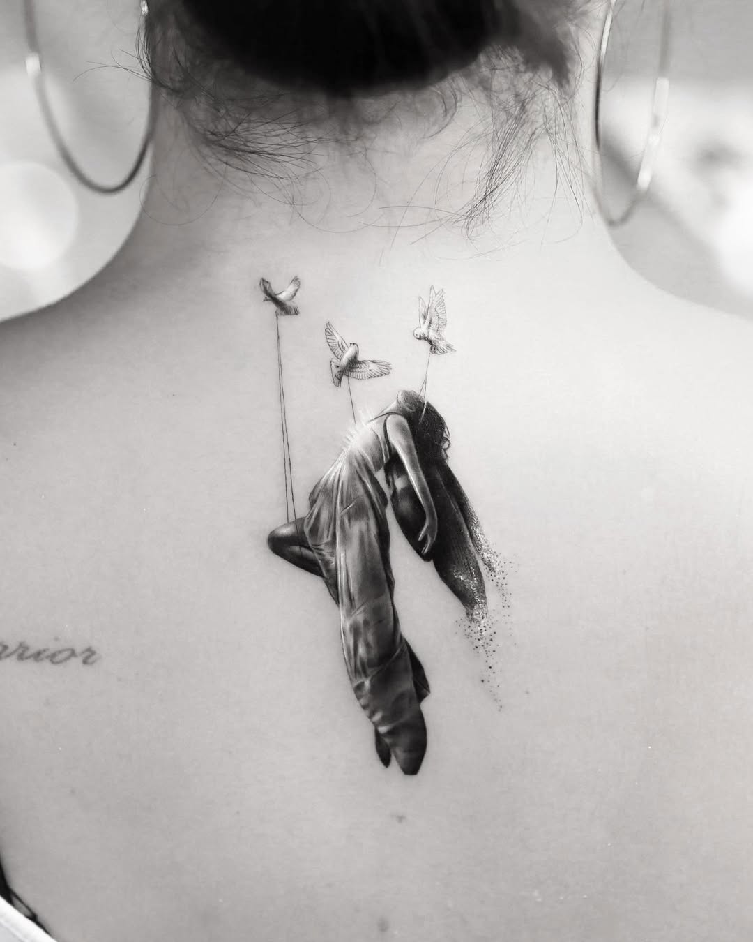 Delicate grayscale silhouette of a draped woman, birds lifting.