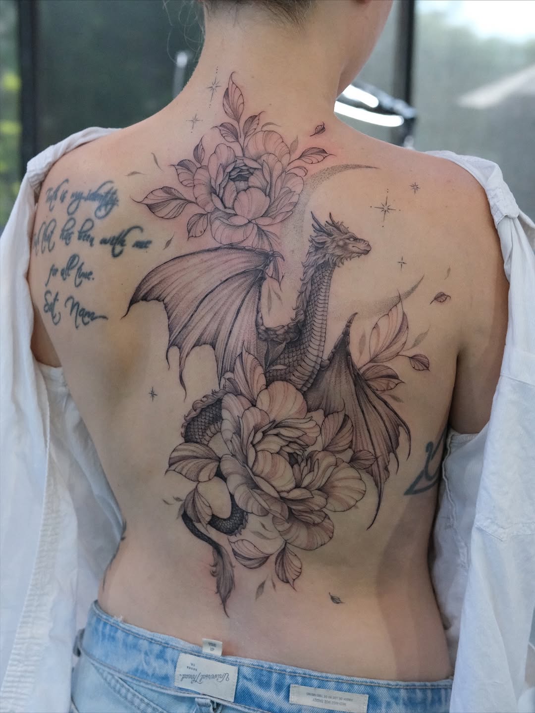 Intricate dragon and floral tattoo