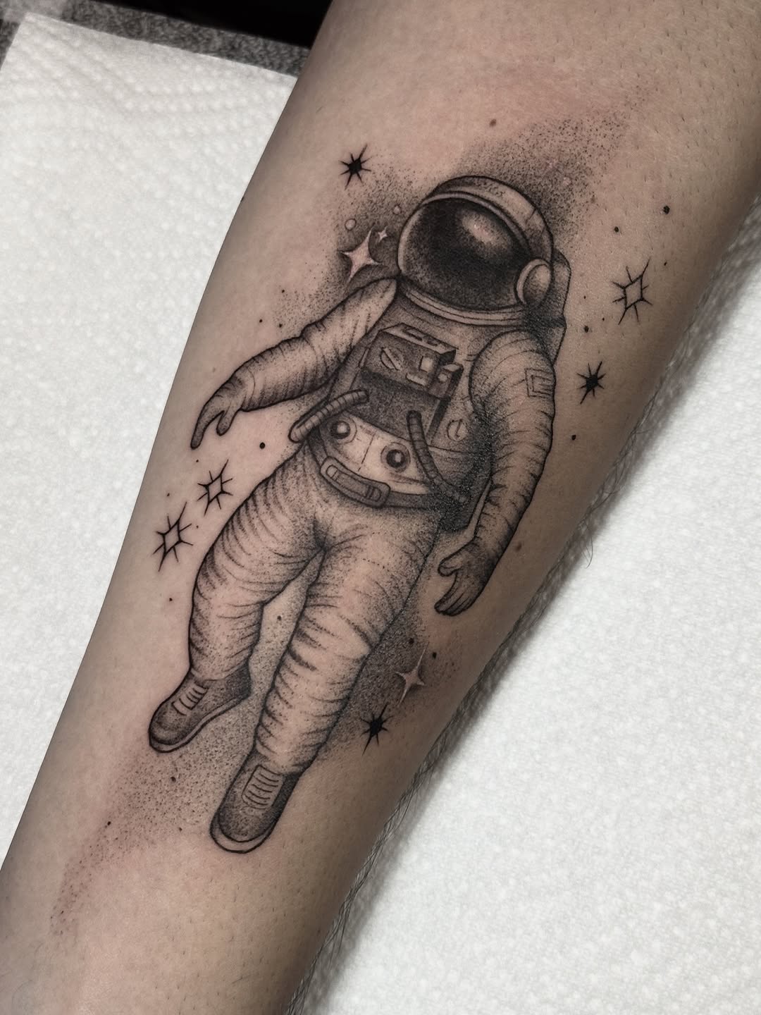 Detailed blackwork astronaut drifting among speckled stars