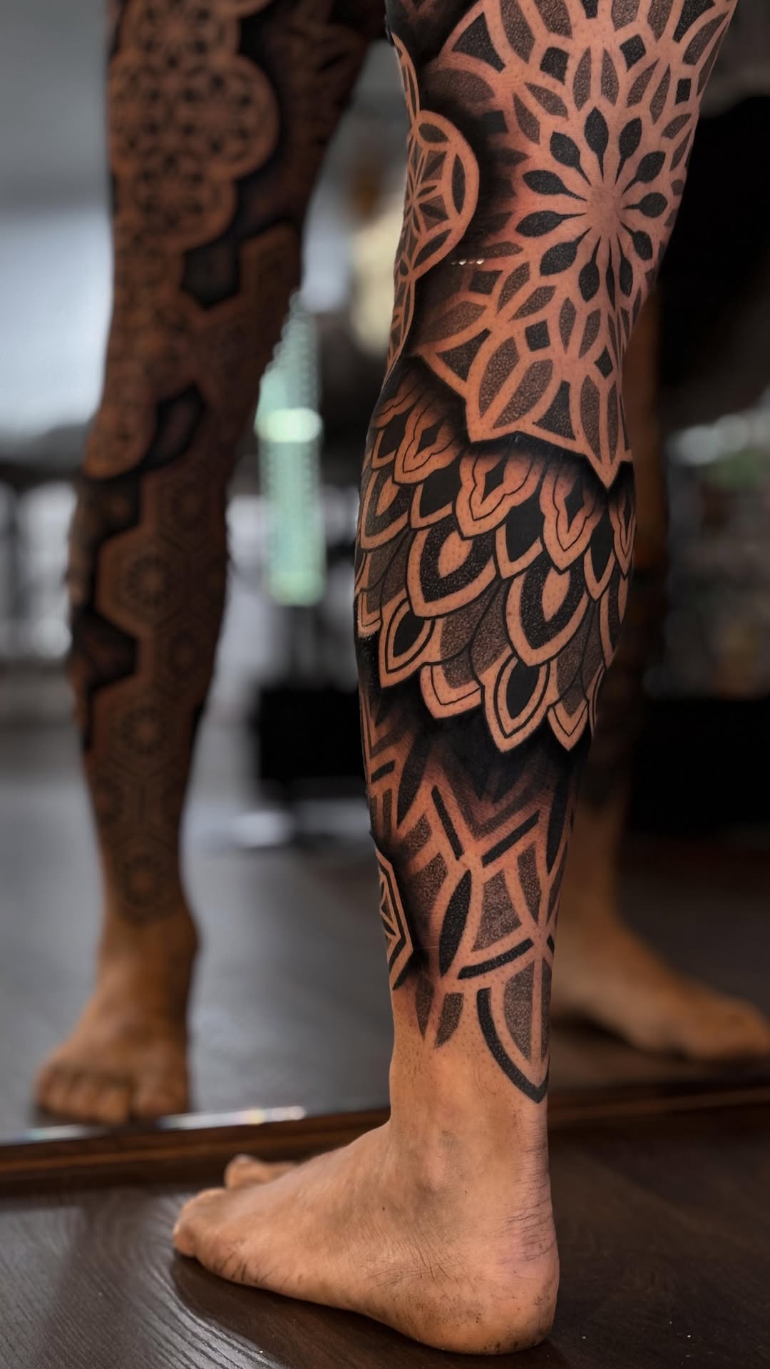 Intricate geometric blackwork sleeve wrapping the leg