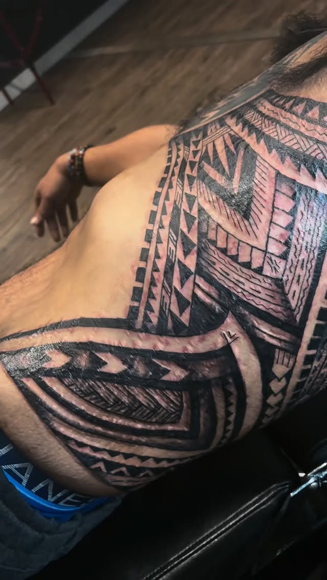 Bold Polynesian tribal geometric sleeve on shoulder and back