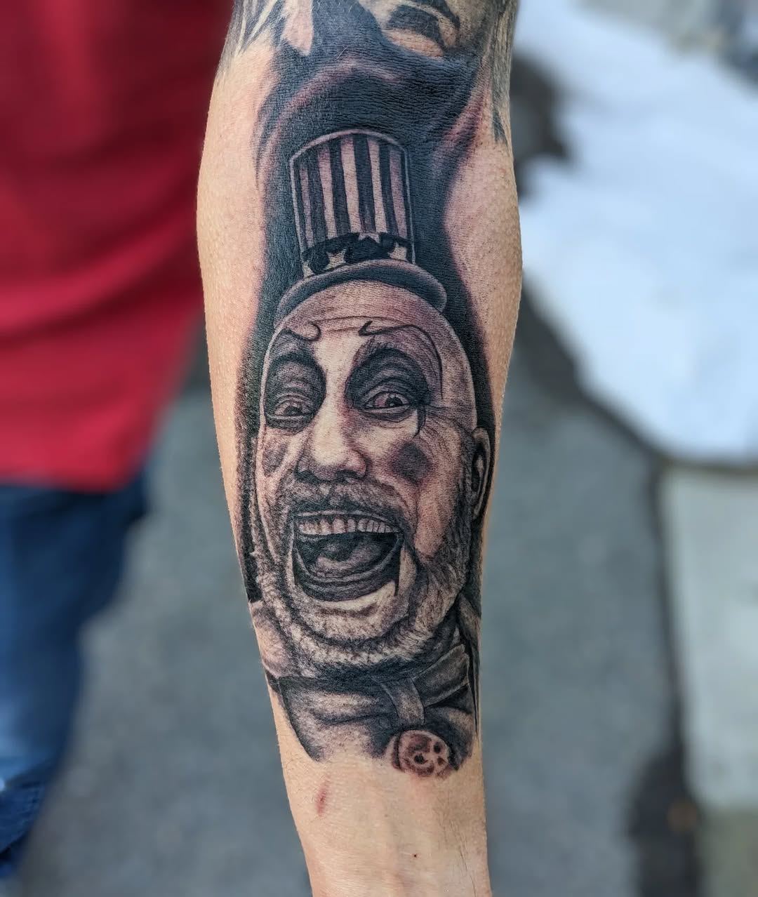 Grayscale Captain Spaulding clown portrait on forearm
