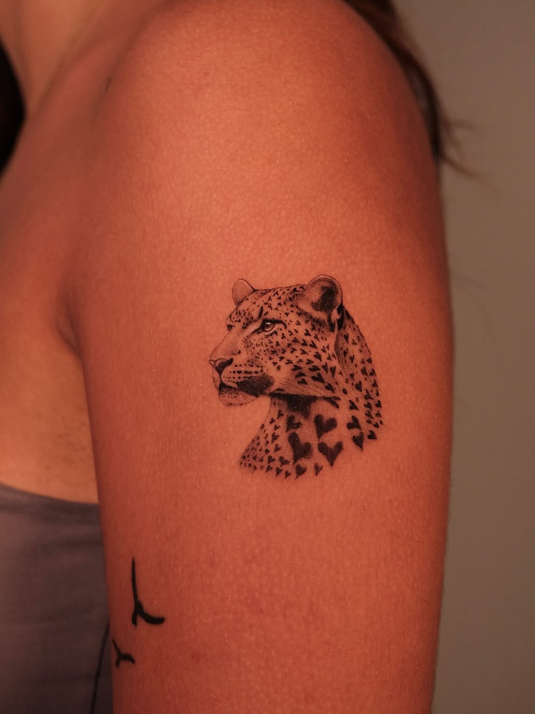 Leopard head with fine-line realism and heart-shaped spots