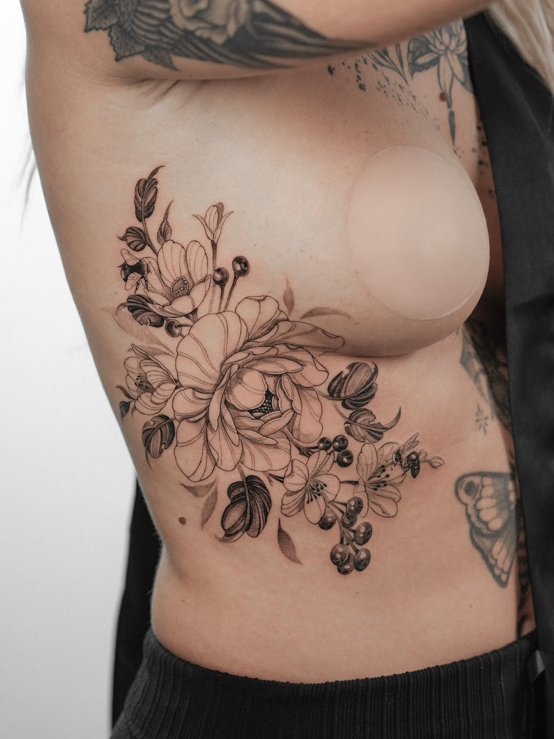 Delicate floral bouquet wraps side torso in fine lines