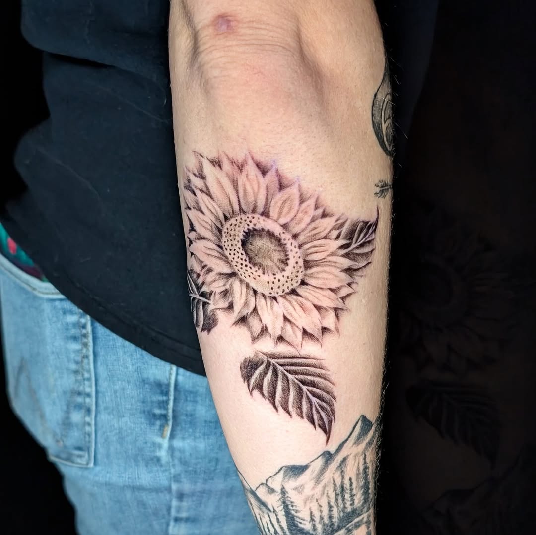 Bold black-and-gray sunflower with detailed center and leaves