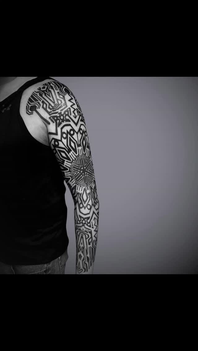 Bold black geometric sleeve with maze-like tribal motifs