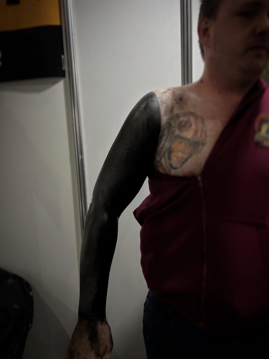 Bold blackout sleeve blankets forearm, hint of shoulder ink