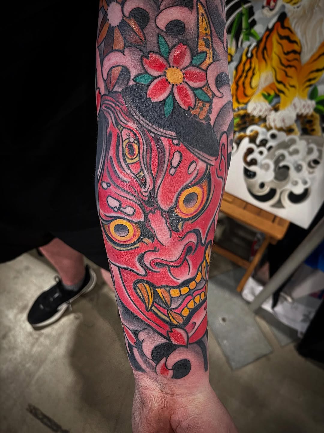 Vibrant pink demon face with bold outlines and floral accents
