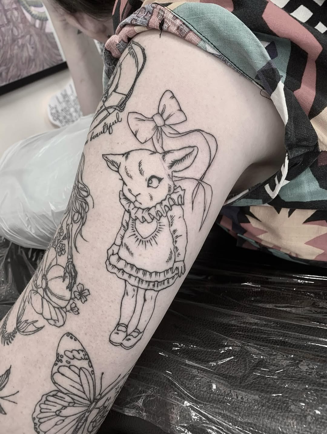 Delicate linework bunny in frilly dress with bow.