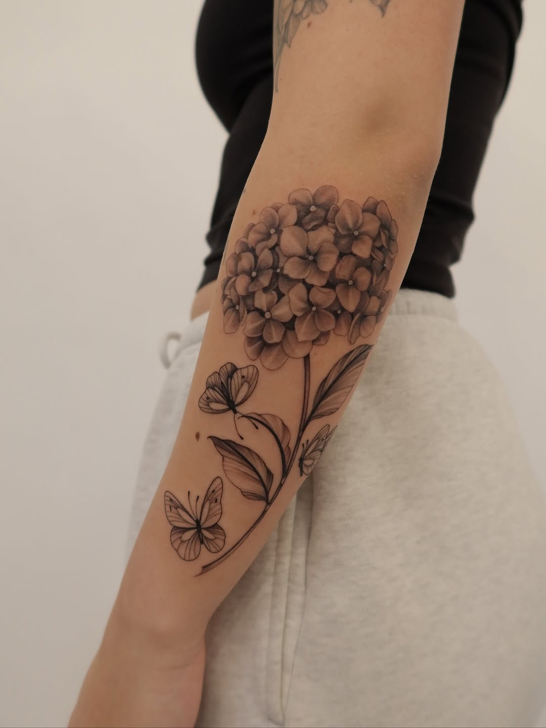 Graceful grayscale hydrangea cluster with delicate butterfly accents.