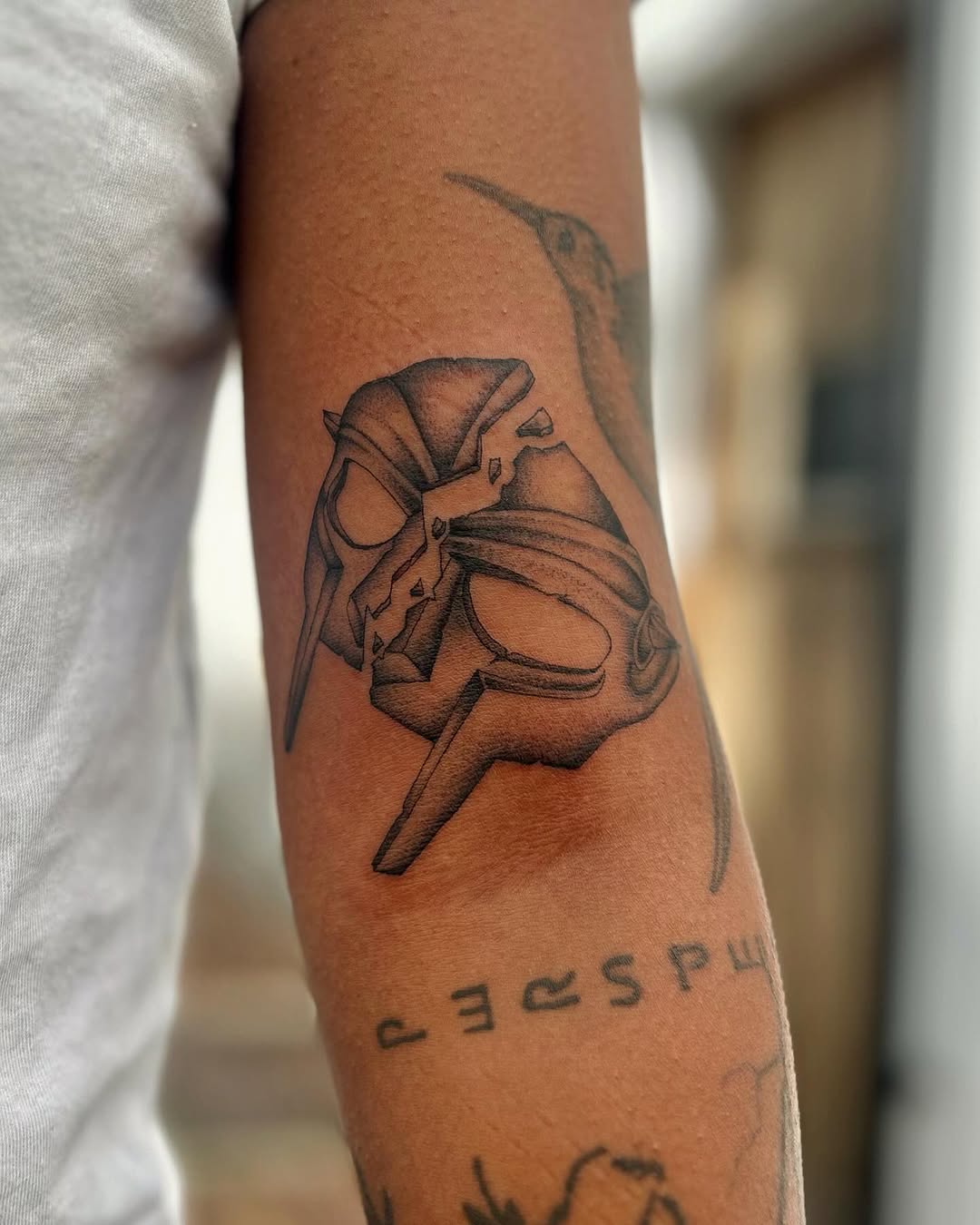 Shattered mask fragment rendered with bold linework and shading.