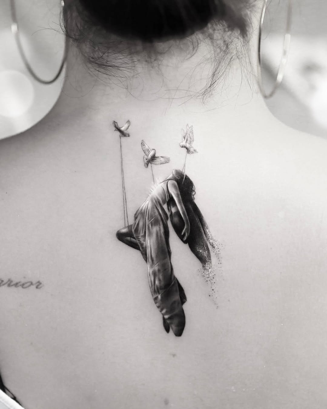 Surreal black-and-gray back piece: draped figure with birds