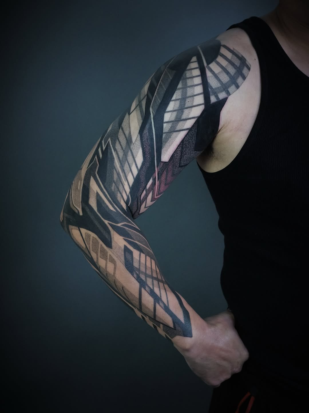 Bold geometric blackwork sleeve with interlocking angular shapes