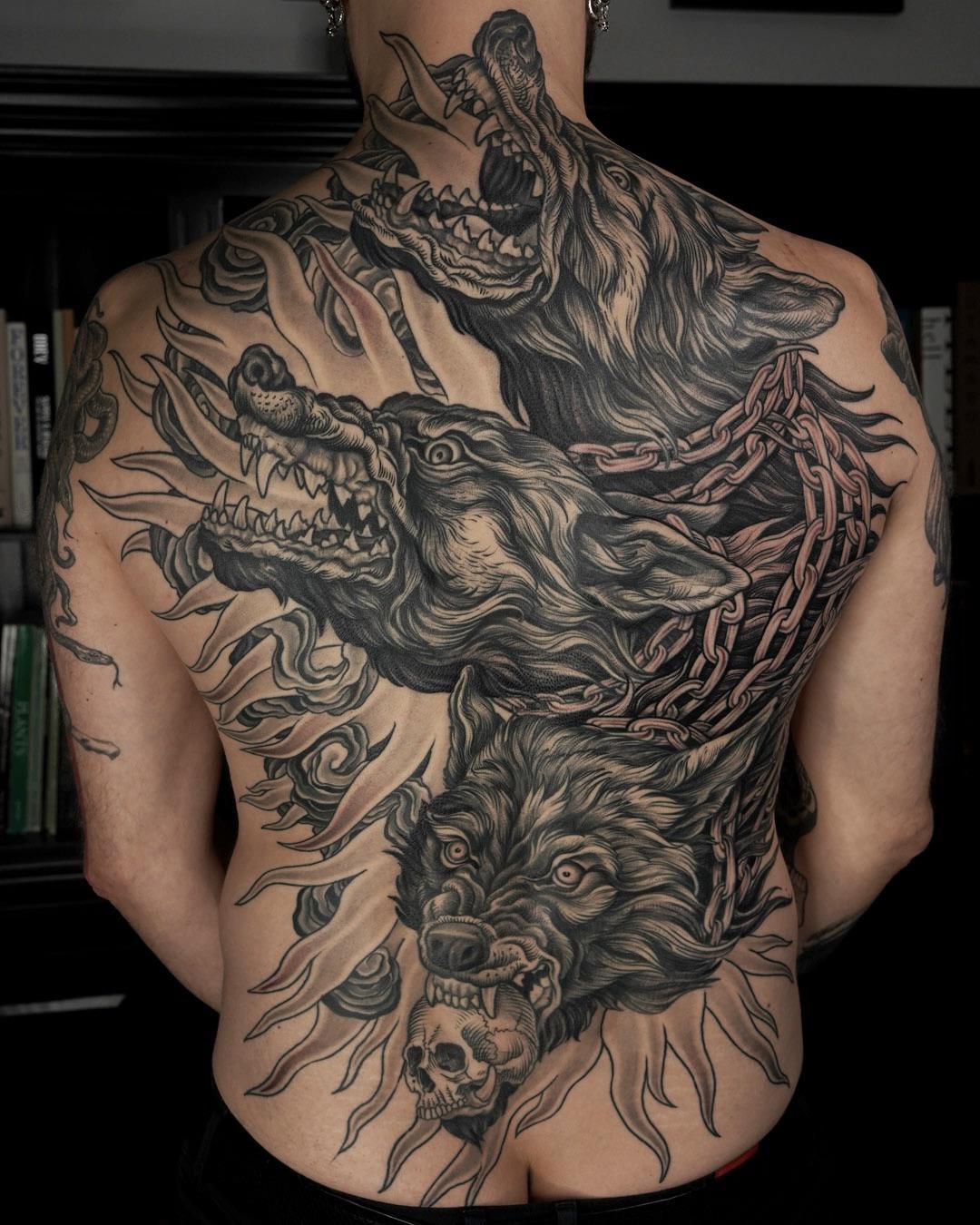 Monstrous three-headed Cerberus back tattoo with chains