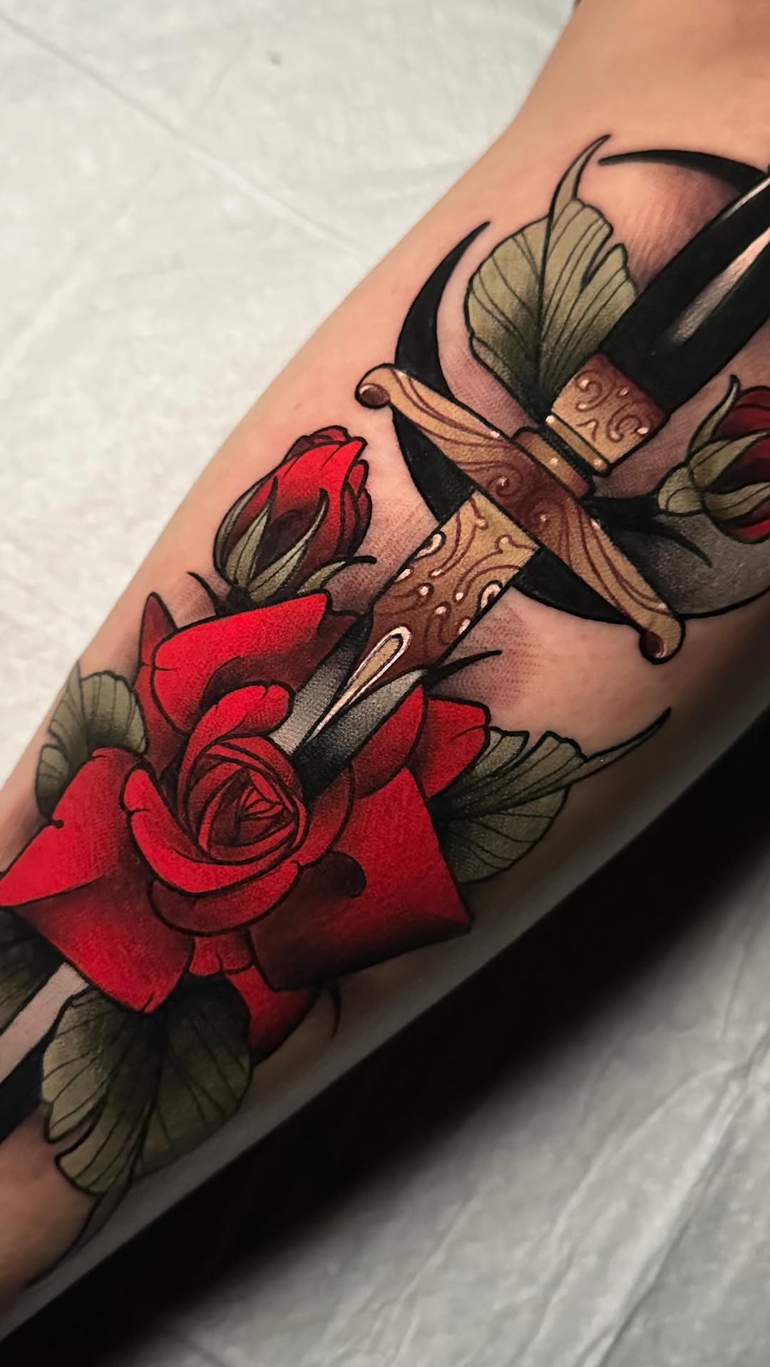 Bold dagger pierced by crimson roses with vibrant shading