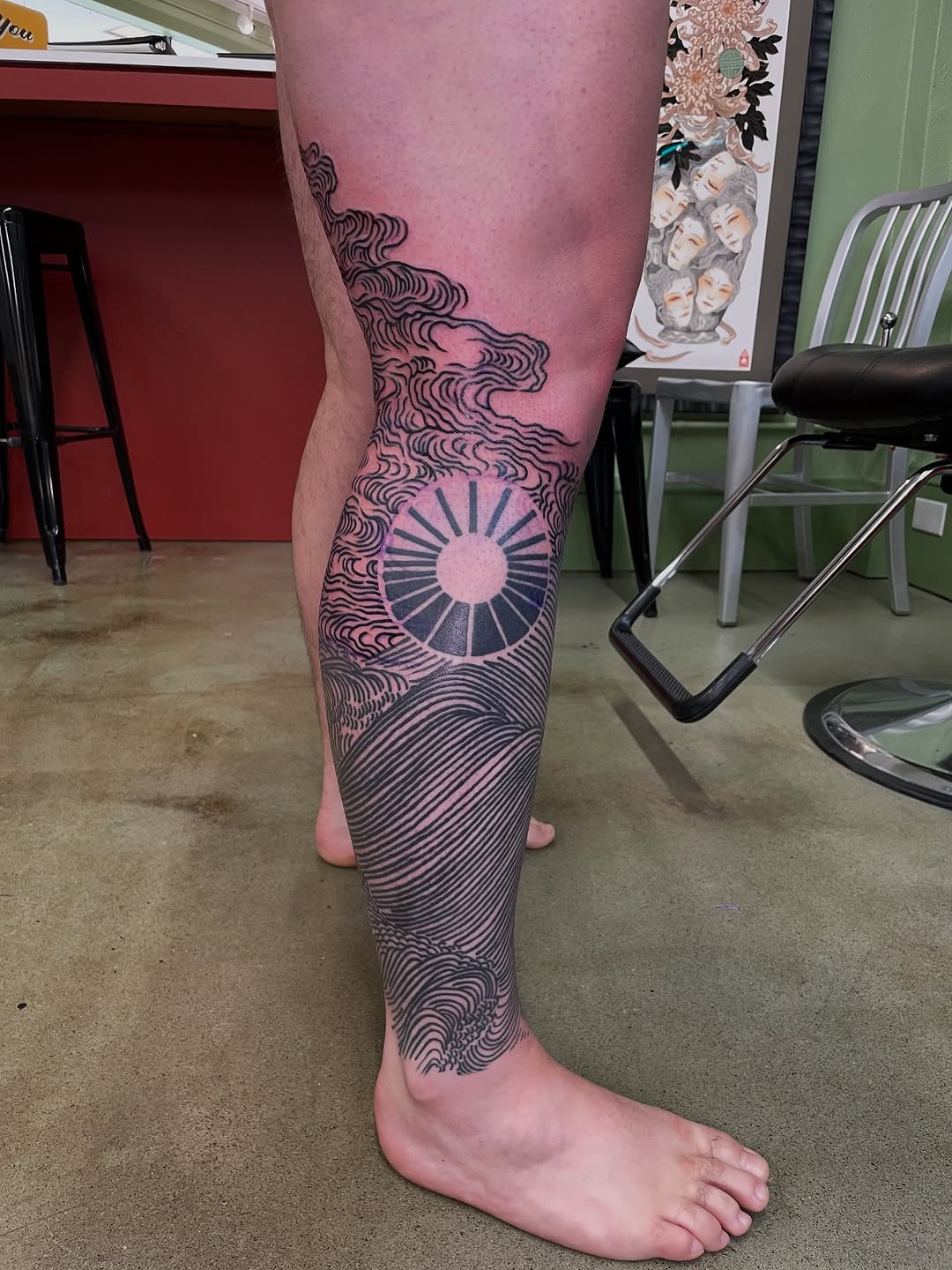 Bold blackwork leg piece: sun disk amid rolling waves