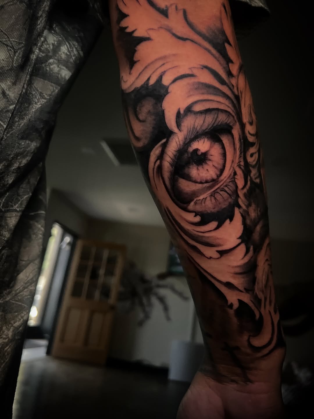 Intense blackwork eye entwined with swirling ornamental motifs