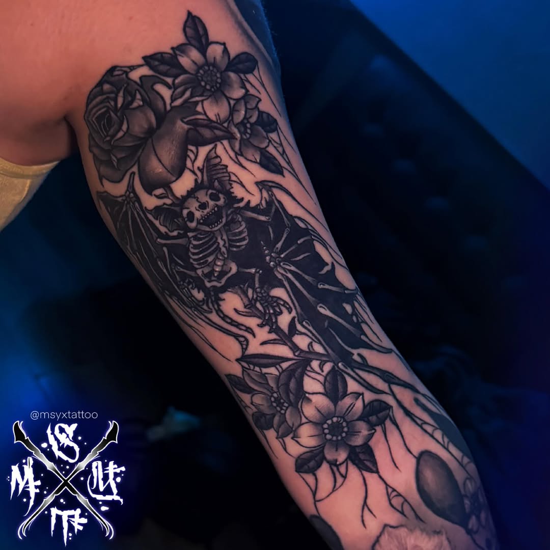 Intricate blackwork skeleton bat entwined with blooming flowers