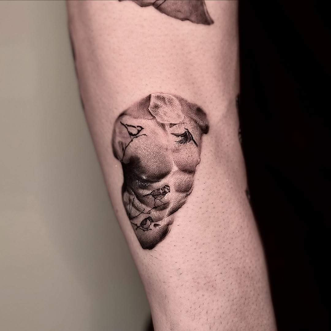 Monochrome sculpted male torso with tiny birds