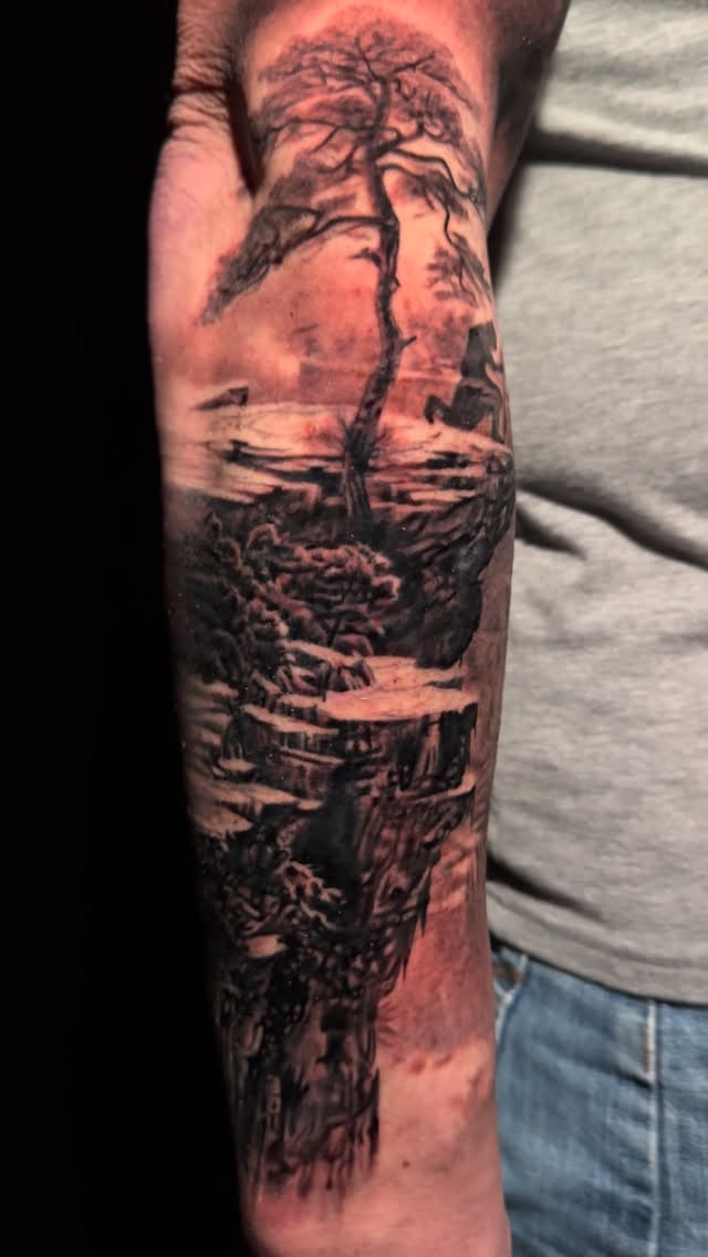 Moody grayscale landscape with windswept tree and rocks.