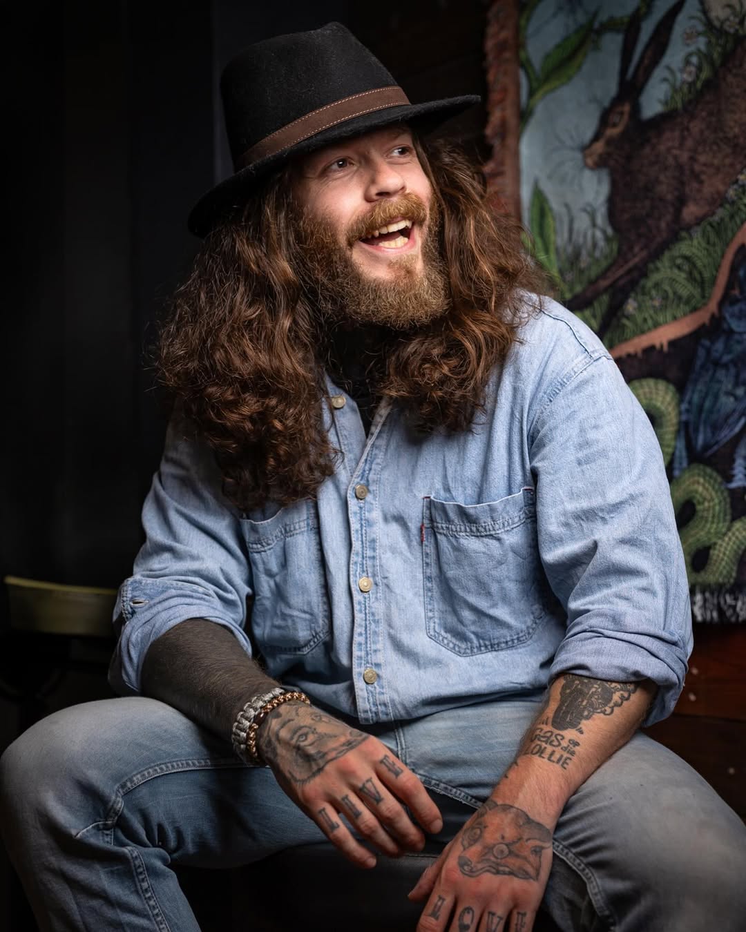 Charismatic bearded artist sporting bold hand tattoo art