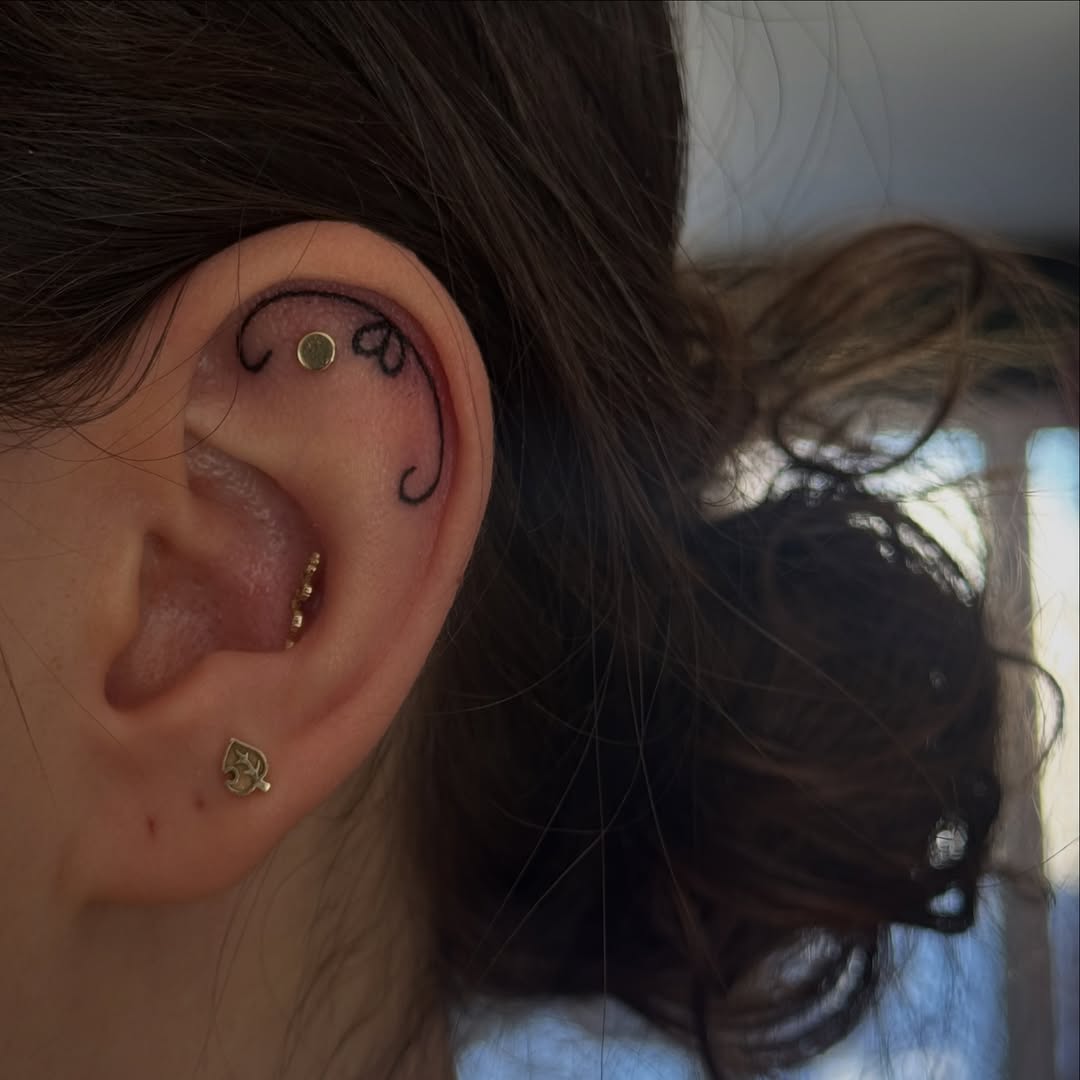 Delicate double-curved ornamental linework around the ear.