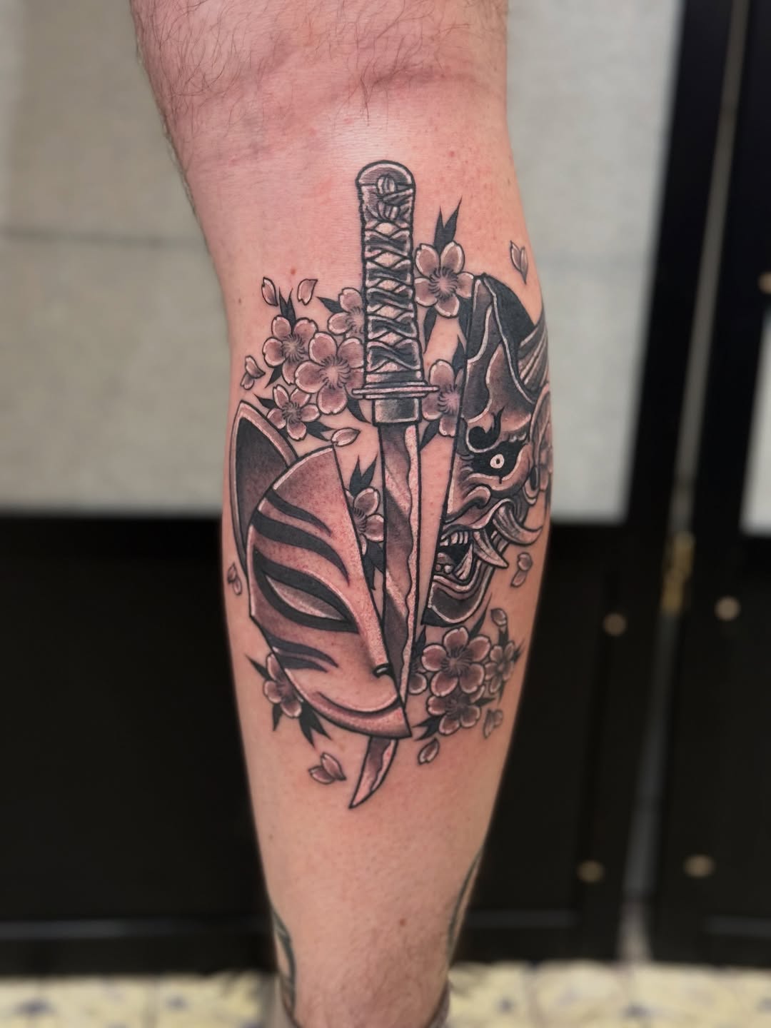 Bold katana with blooming sakura in blackwork style