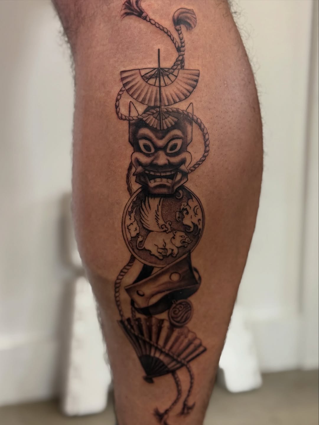 Dramatic blackwork oni mask with rope and fan.