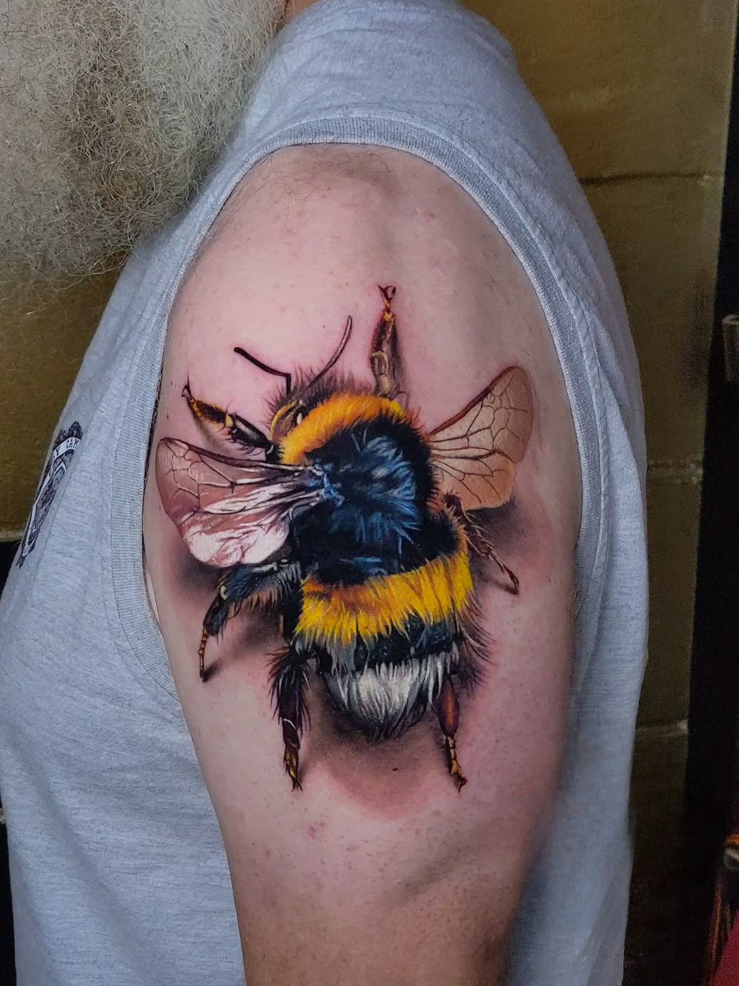 Hyper-realistic bumblebee tattoo with vivid yellow bands