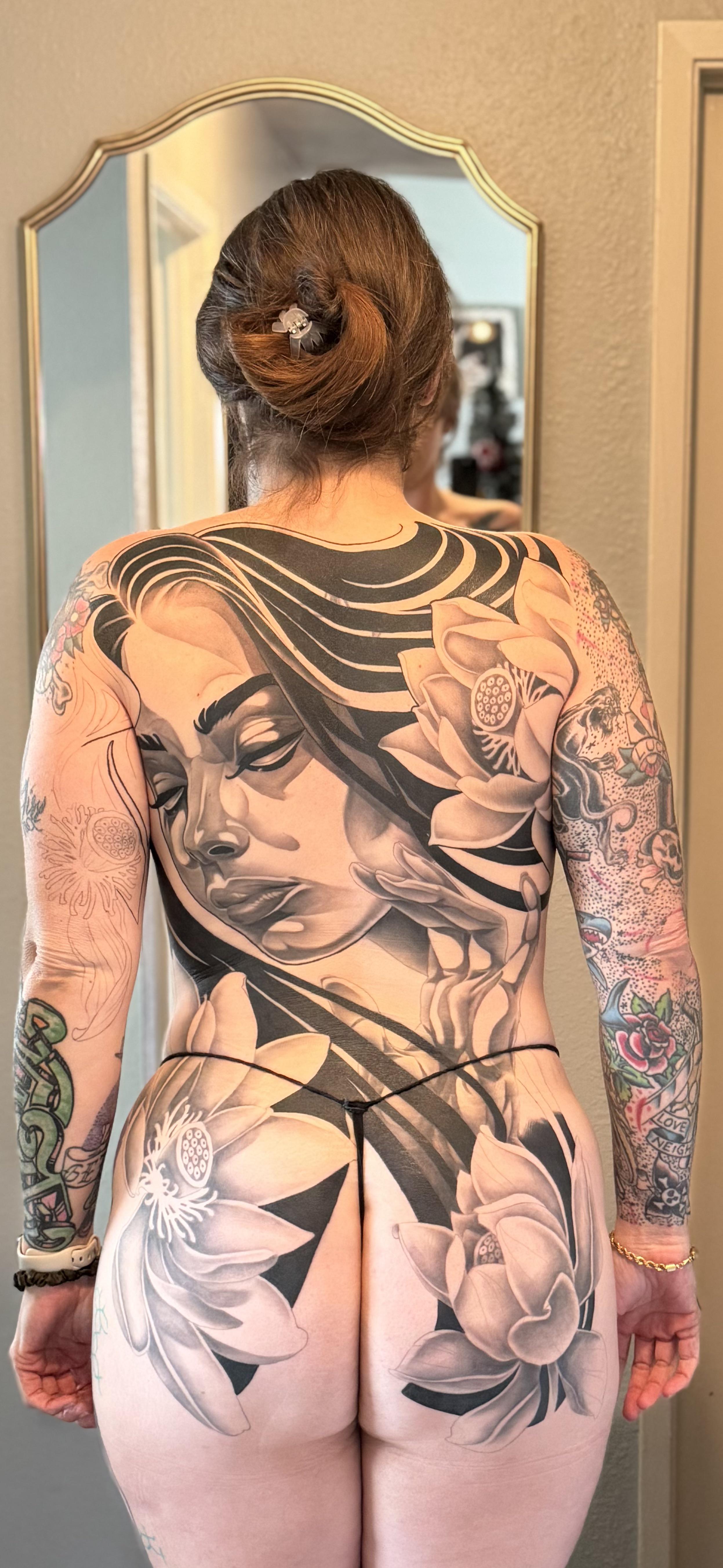 Monumental grayscale back piece featuring a serene female portrait and lotus blossoms.