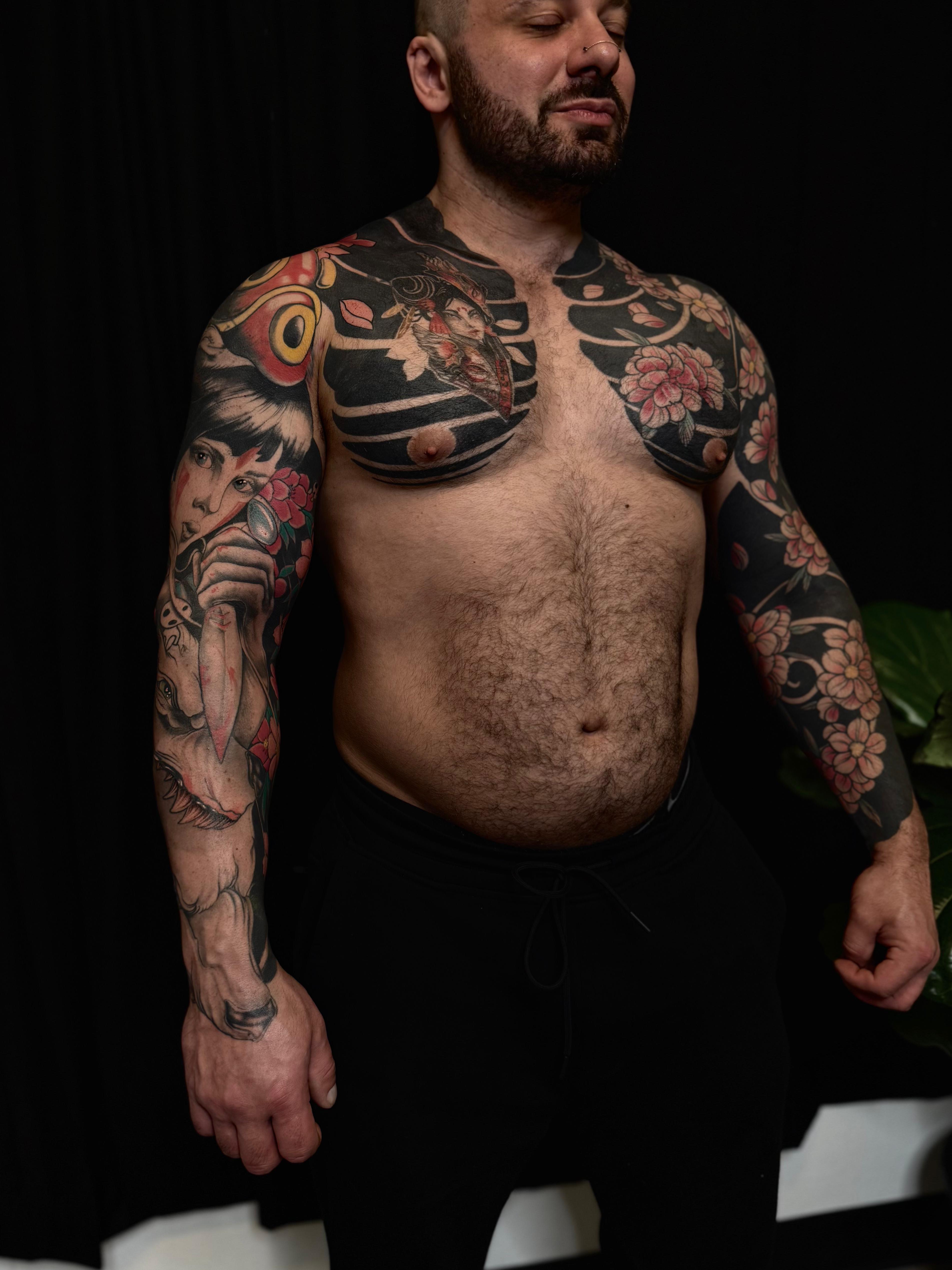 Bold blackwork chest plate with pink blossoms and portrait sleeves