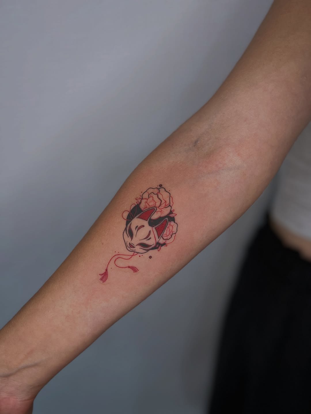 Delicate Japanese fox mask with red blossom accents