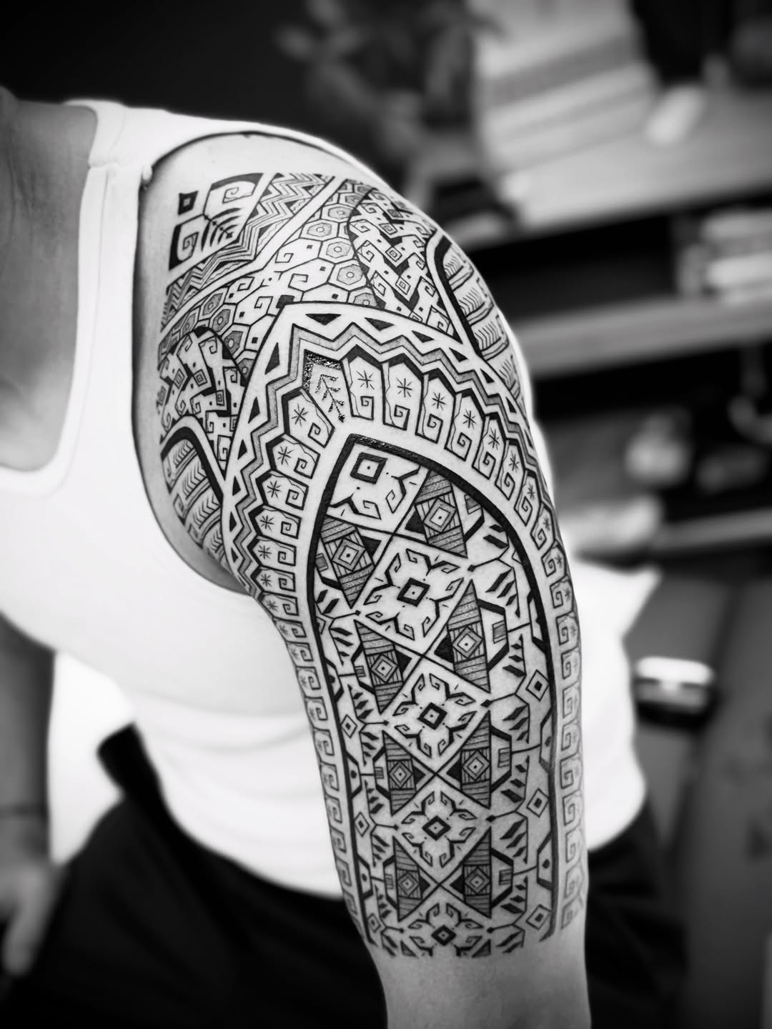Intricate blackwork geometric sleeve with tribal motifs