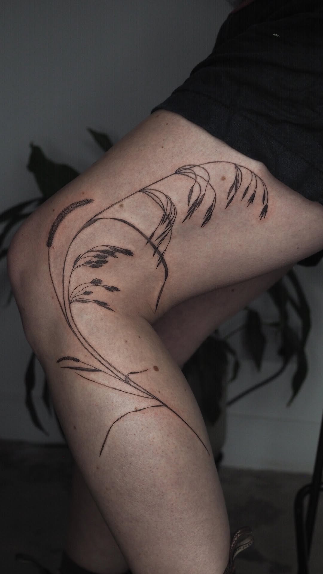 Delicate fineline grasses wrap the upper arm in motion