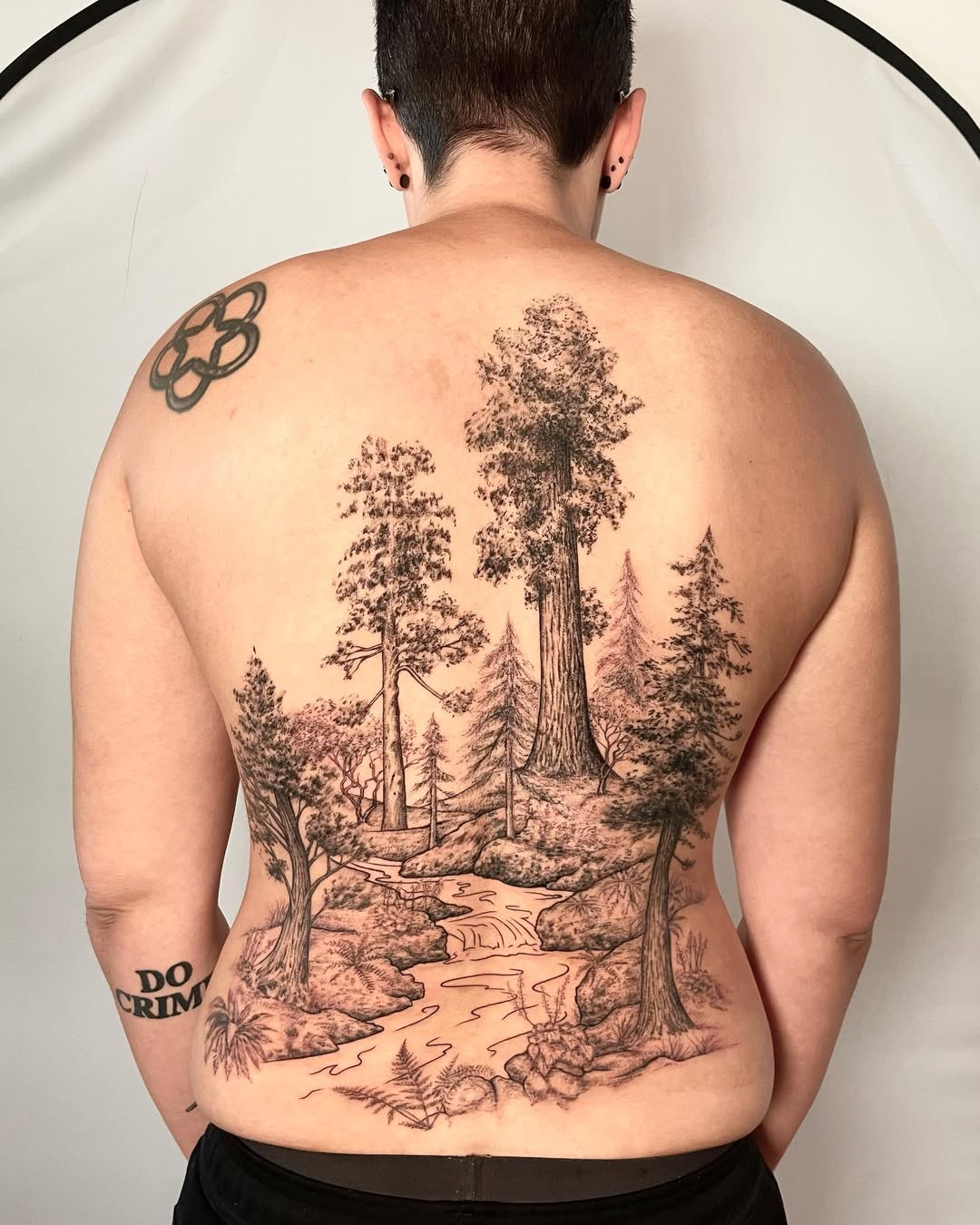 Intricate blackwork forest landscape with towering pines