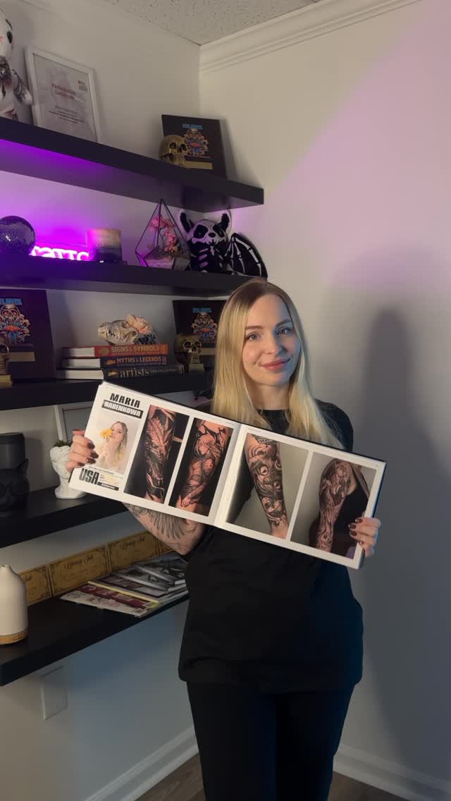 Confident tattoo artist displays bold black-and-gray sleevework.