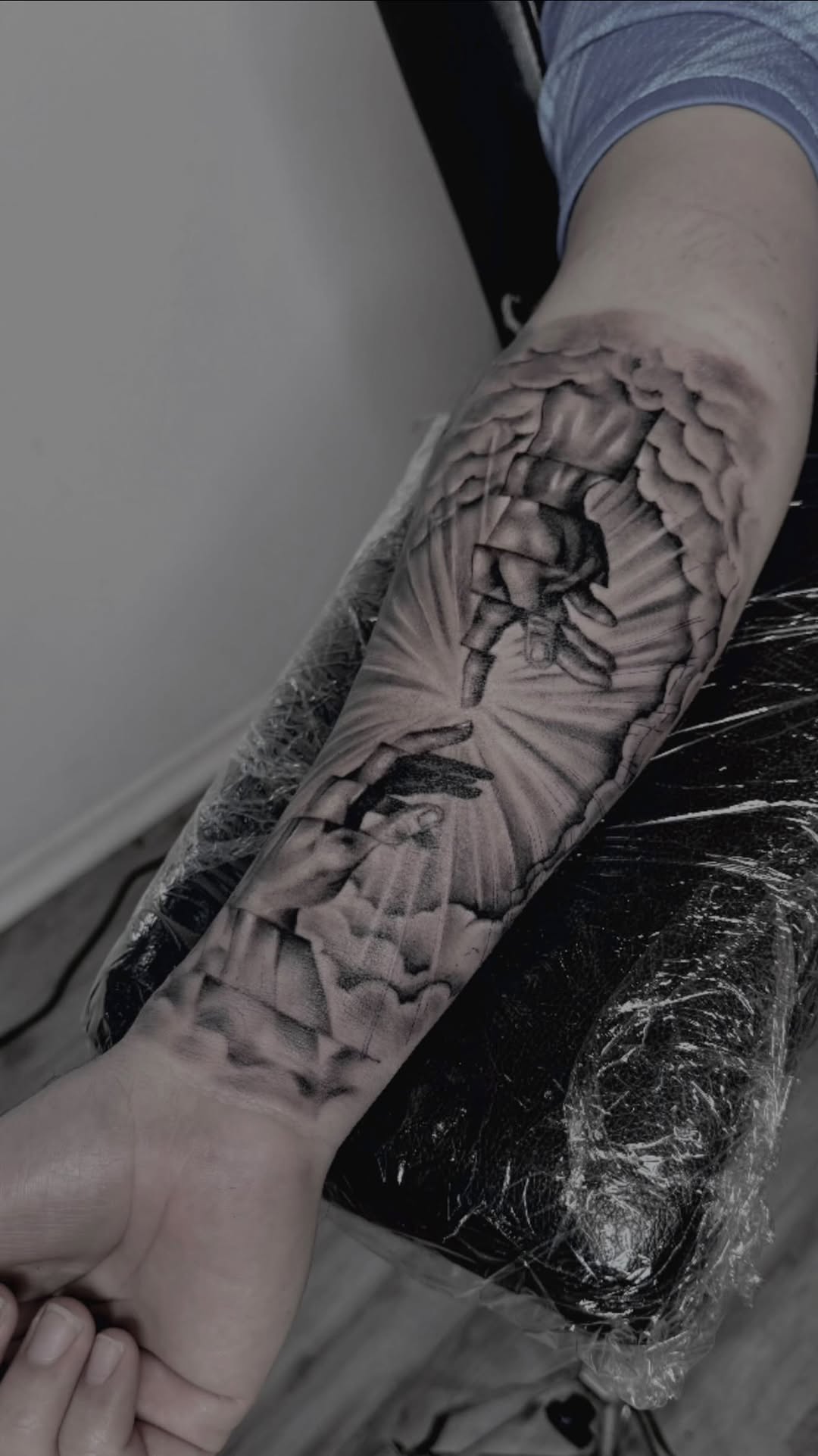 Grayscale Creation of Adam-inspired hands amid radiant rays