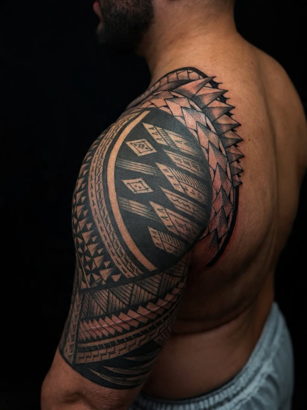 Bold Polynesian geometric tribal tattoo on shoulder