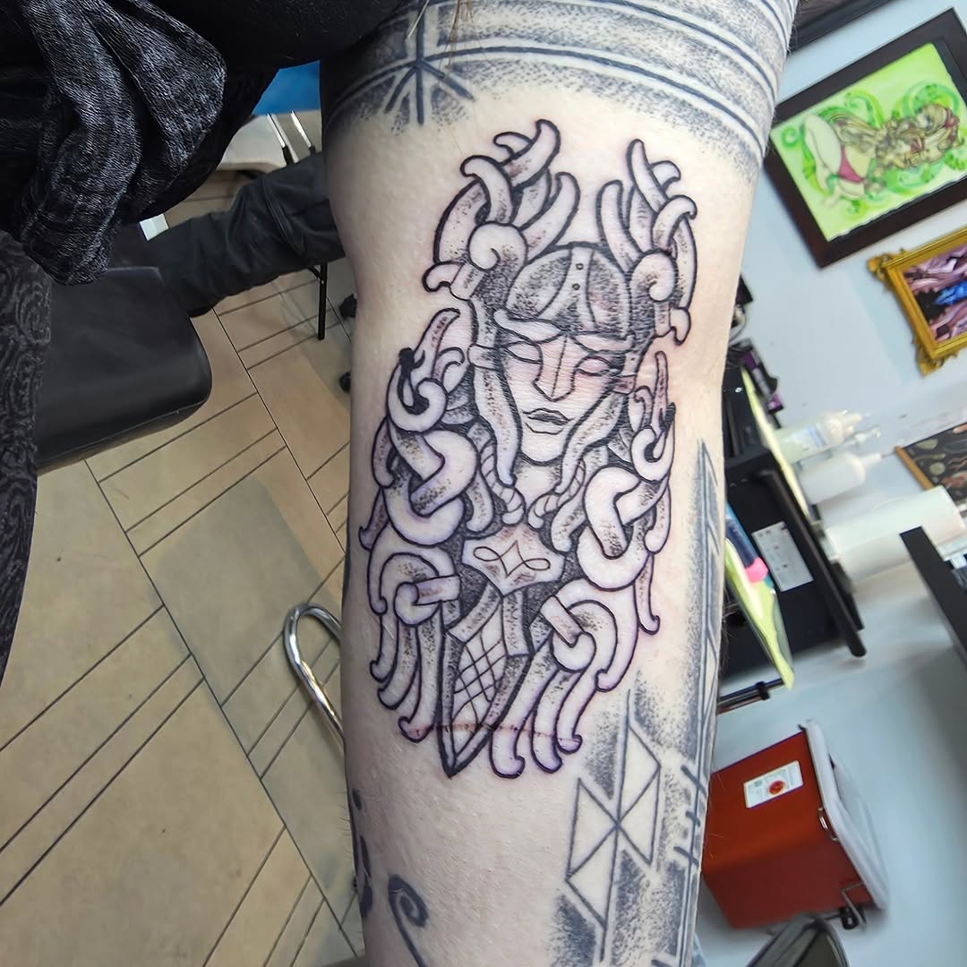 Bold Valkyrie head with winged helmet, wrapped in chains.