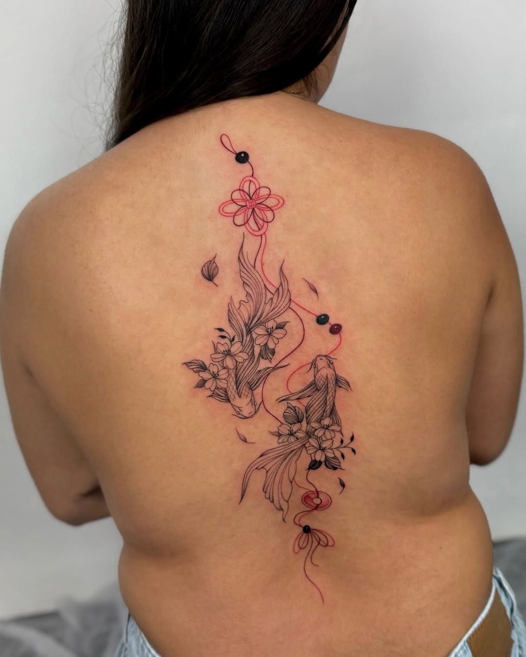 Delicate koi and floral linework with red accents