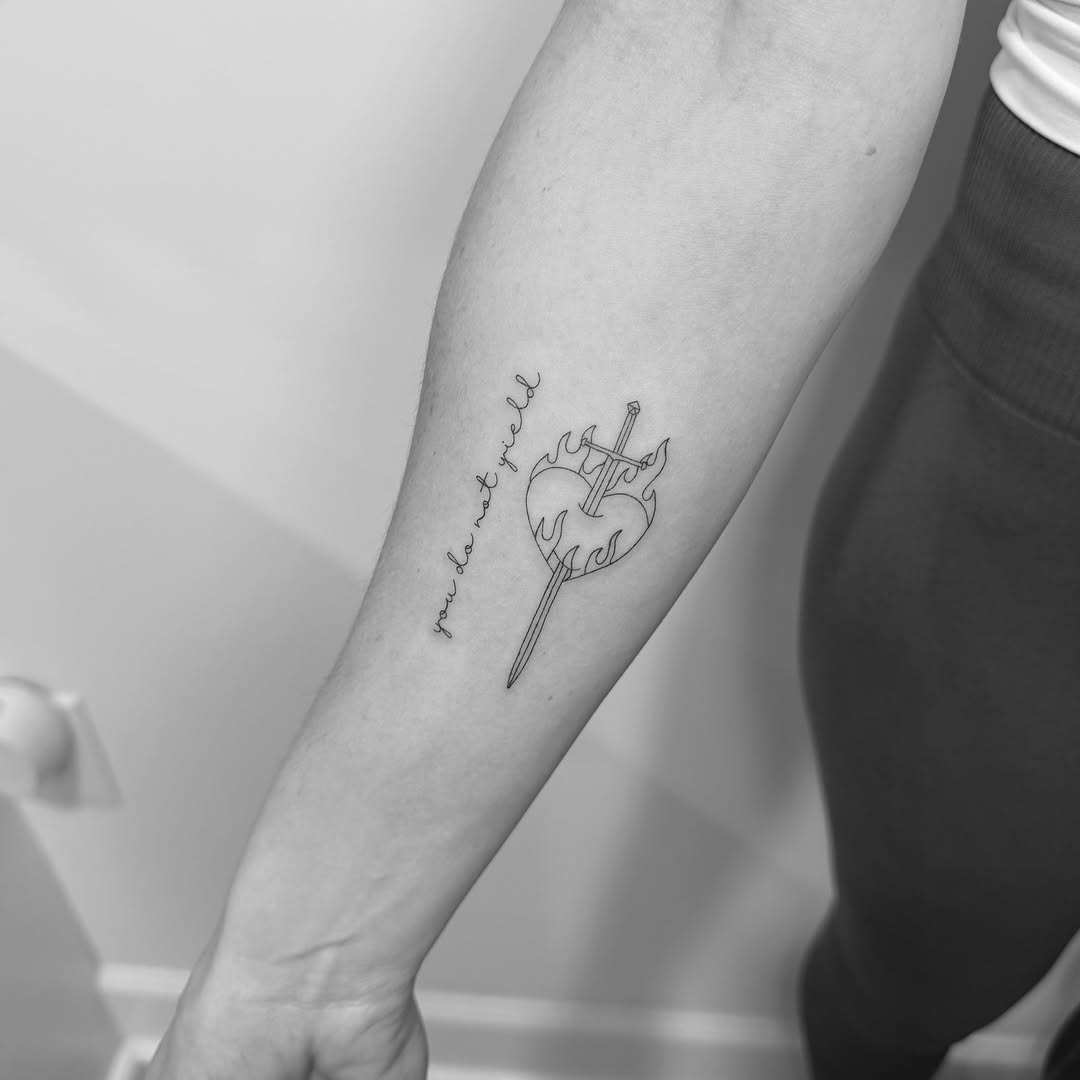 Flaming heart pierced by sword, cursive motto.